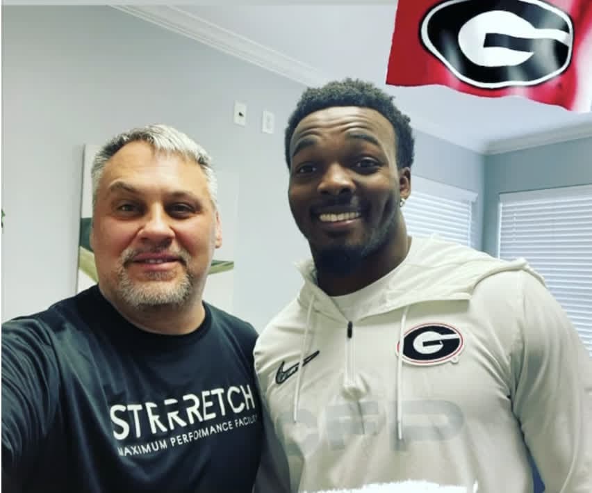 Nakobe Dean with a Strrretch practitioner at the studio